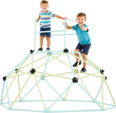 Two young boys are playing on a geometric climbing dome in a studio setting with a white background.