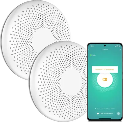 Two white circular CO detectors are shown next to a smartphone displaying a CO alarm notification.