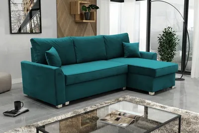 A teal sectional sofa is shown in a modern living room setting, with a glass coffee table in the foreground.