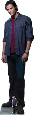 A cardboard cutout of Sam Winchester from Supernatural, wearing a blue denim shirt over a red t-shirt and dark jeans.