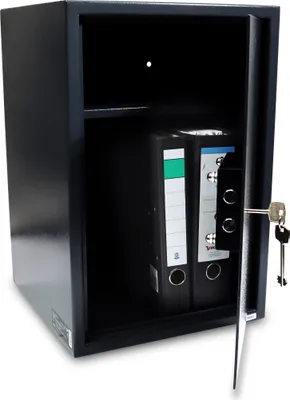 An open safe with two binders inside, a key in the lock.