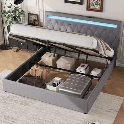 A bed with its storage compartment open, revealing various items stored inside. The bed has a tufted headboard with LED lighting.