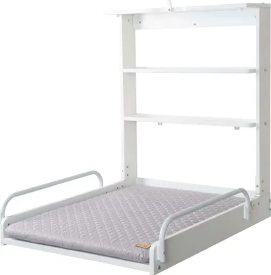 A white wall-mounted changing table with a gray padded mat and two shelves above.
