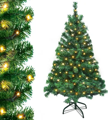 A green artificial Christmas tree decorated with yellow lights, standing on a black metal stand, with a close-up of the tree branches on the left.