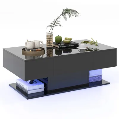 A modern, glossy black coffee table with LED lighting, decorated with a vase of greenery, two mugs on a tray, a book, and a bowl of fruit.