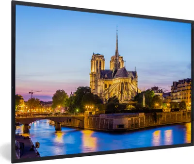 Produktbild von MuchoWow® Gerahmtes Poster Eine beleuchtete Notre Dame mit blauem Wasser vor ihr in Frankreich 90x60 cm - Poster mit Schwarzem Bilderrahmen Wandposter Rahmen Foto Bilder - Fotorahmen - Foto-Plakat