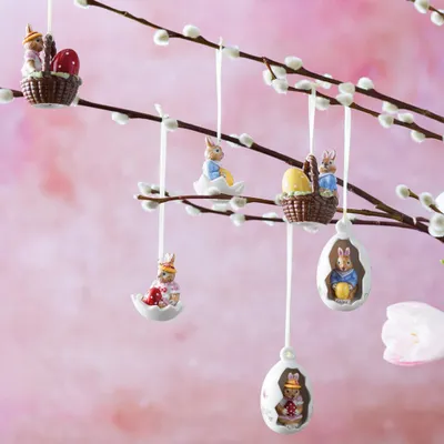 Easter ornaments shaped like bunnies and eggs hanging from pussy willow branches.