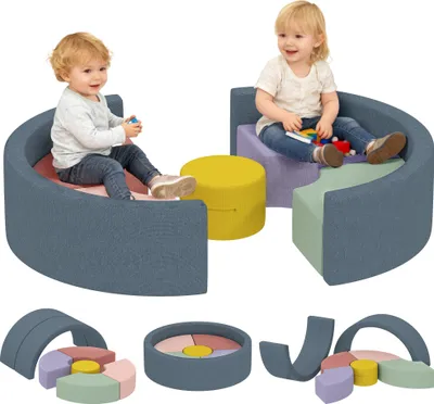 Children playing with soft building blocks arranged in a circular seating area and other configurations.