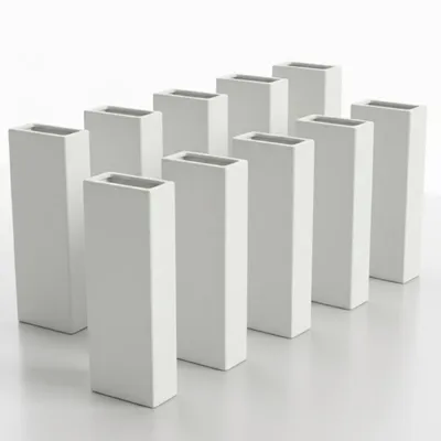 A group of white ceramic vases arranged in rows on a white surface.