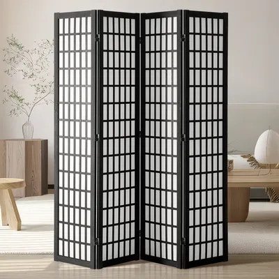 A four-panel folding room divider with a black frame and white grid pattern, set in a well-lit room with furniture.