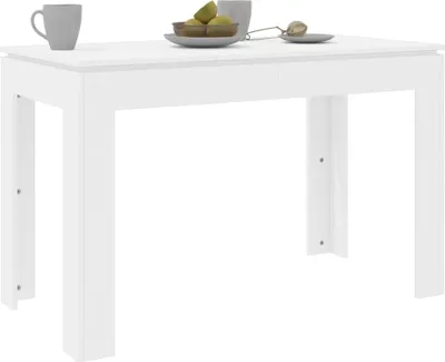 A white table with a bowl of fruit and a mug on it.