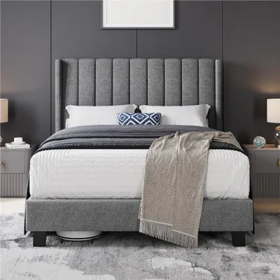 A bedroom scene featuring a bed with a gray upholstered headboard and frame, dressed with white bedding and a beige throw blanket.