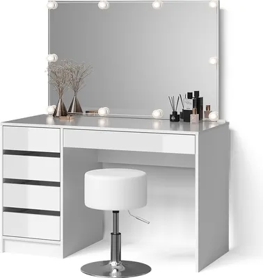 A white vanity table with a large mirror and LED lights, a white stool, and decorative items on the table.