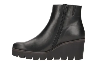 A black wedge bootie is shown from the side against a white background.