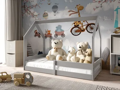A child's bedroom with a house-shaped bed decorated with stuffed animals and a whimsical mural.
