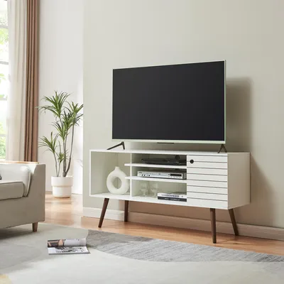 A modern living room with a TV stand, TV, sofa, and plant.
