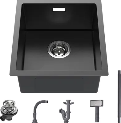 A dark gray sink with various plumbing accessories laid out below it.