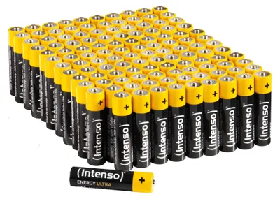 A large pile of AAA batteries, with one battery in the foreground.
