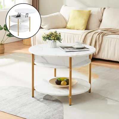 A round coffee table with a marble-like finish and gold legs is placed in a living room setting next to a sofa.