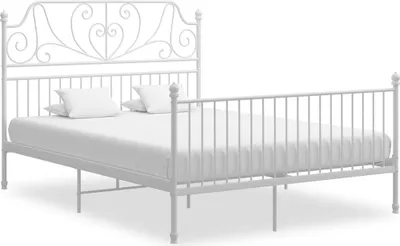 A white metal bed frame with a headboard decorated with a heart motif and decorative scrolls.