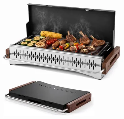 Zdjęcie produktu dla KOMFOTTEU, grill węglowy, przenośny i składany. Posiada ruszty grillowe z 2 regulowanymi wysokościami, drewniane uchwyty, zamek magnetyczny. Idealny do grillowania i biwakowania