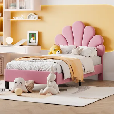 A child's bedroom with a pink bed, desk, and shelves.