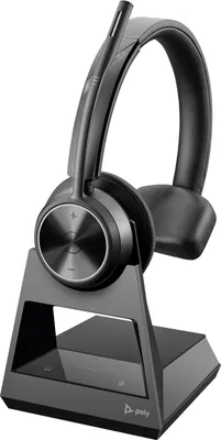 A black wireless headset with a microphone boom is shown on its charging dock.