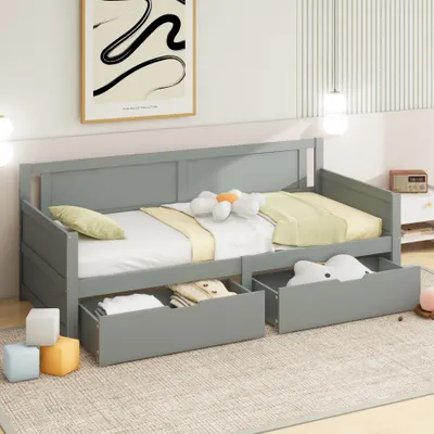 A gray daybed with two drawers underneath, set up in a room with a poster on the wall and a rug on the floor.