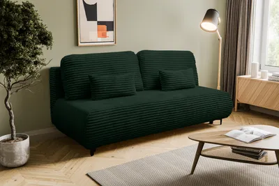 A dark green corduroy sofa with two throw pillows is shown in a living room setting.