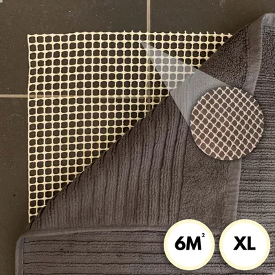 A close-up view of the back of a rug with a grid-like backing and a ribbed texture on the front.