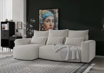 A modern living room with a beige sectional sofa, a large abstract painting on the wall, and a black cabinet.