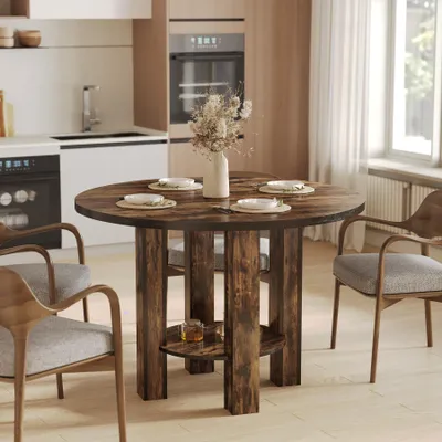 A round wooden dining table set for four in a modern kitchen setting.