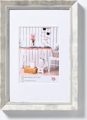 A framed picture with a mat, showing a rustic interior scene.