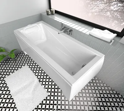 A modern white bathtub in a bathroom setting with patterned tiles.