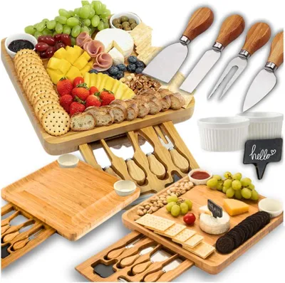 A collection of cheese boards and serving platters with various food items and utensils.