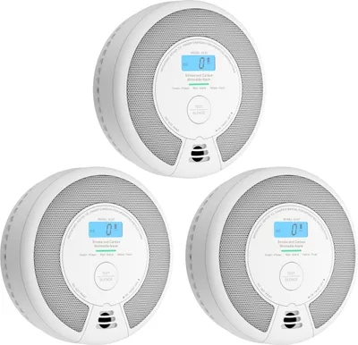 Three white smoke and carbon monoxide detectors are arranged in a cluster against a white background.