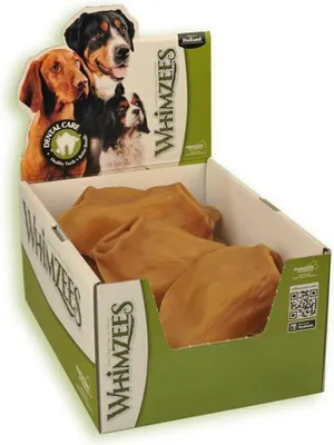 A display box filled with dog chews, with a cardboard header featuring images of dogs and branding.