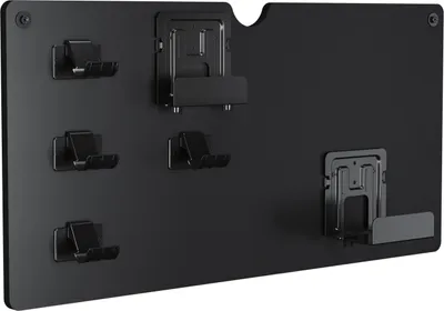 A black wall mount with several hooks and brackets for storing game controllers and headsets.