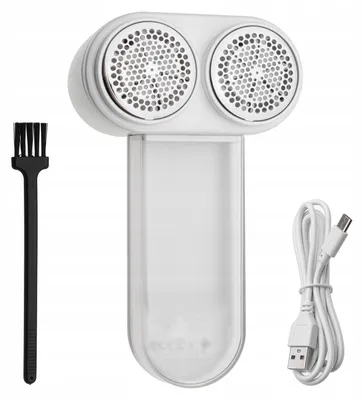 A white rechargeable lint remover with a cleaning brush and a USB charging cable, displayed against a white background.