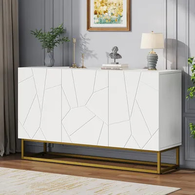 A white sideboard with a geometric pattern on the doors, set on a gold metal frame, displayed in a room with a painting and a lamp on top.