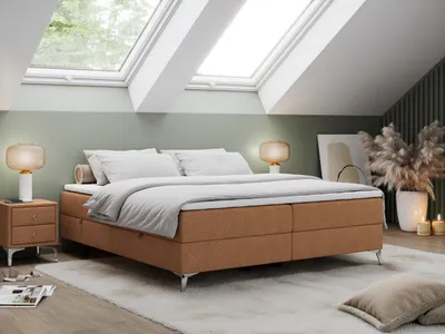 A bedroom scene with a bed, nightstand, and lamps.