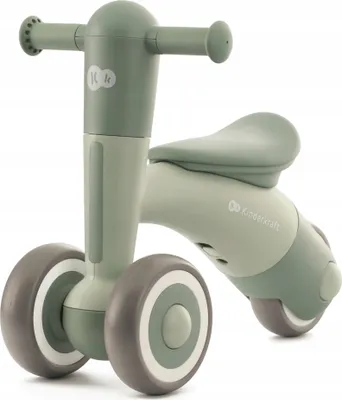 A green and gray balance bike for toddlers is shown against a white background.