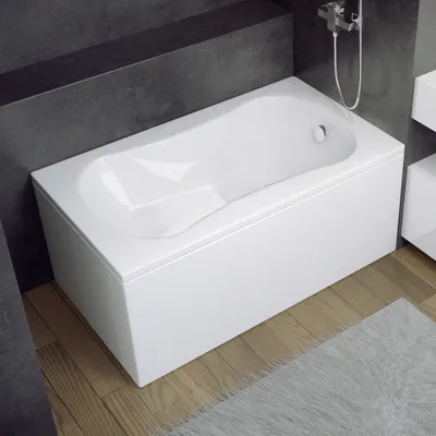 A modern bathroom with a white rectangular bathtub against a dark gray tiled wall.