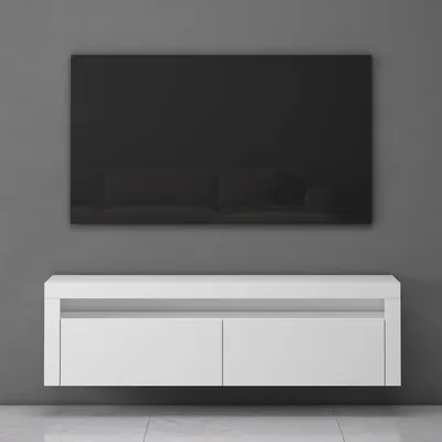 A white floating TV stand with two drawers is mounted on a gray wall, with a large black TV screen mounted above it.
