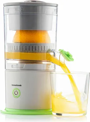 An automatic juicer is shown with an orange being juiced and the juice flowing into a glass.