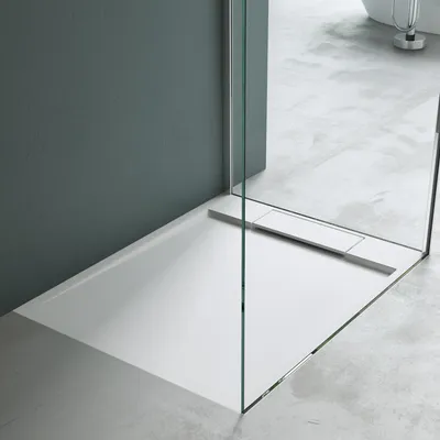 A modern bathroom shower tray with a glass partition.