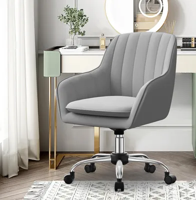 A gray office chair is placed next to a vanity table with a mirror and various items on it.