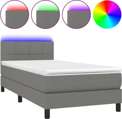 A single bed with a headboard and mattress, illuminated by blue LED lights.