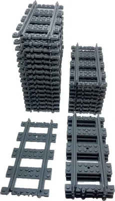 Several stacks of dark gray LEGO train tracks are arranged on a white background.