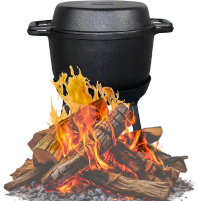 A black cast iron Dutch oven is placed over a fire pit with burning logs.